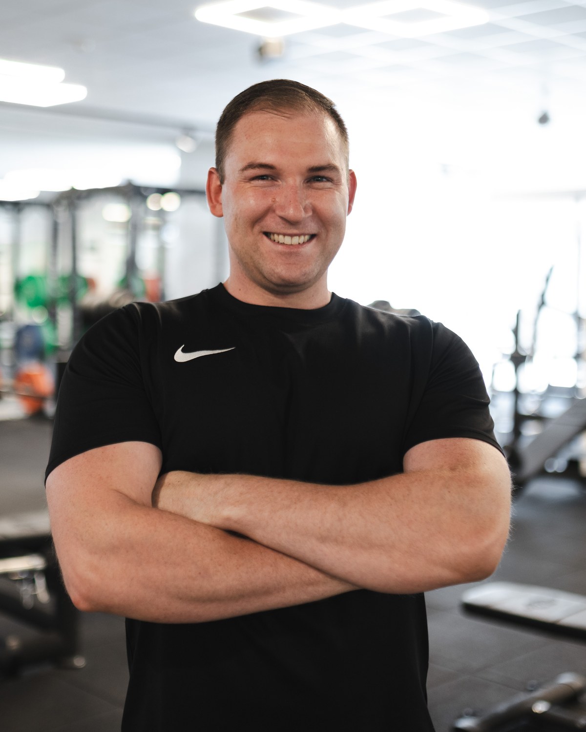 Justin Scheu-Doms mit verschränkten Armen auf der Trainingsfläche im GYM100.