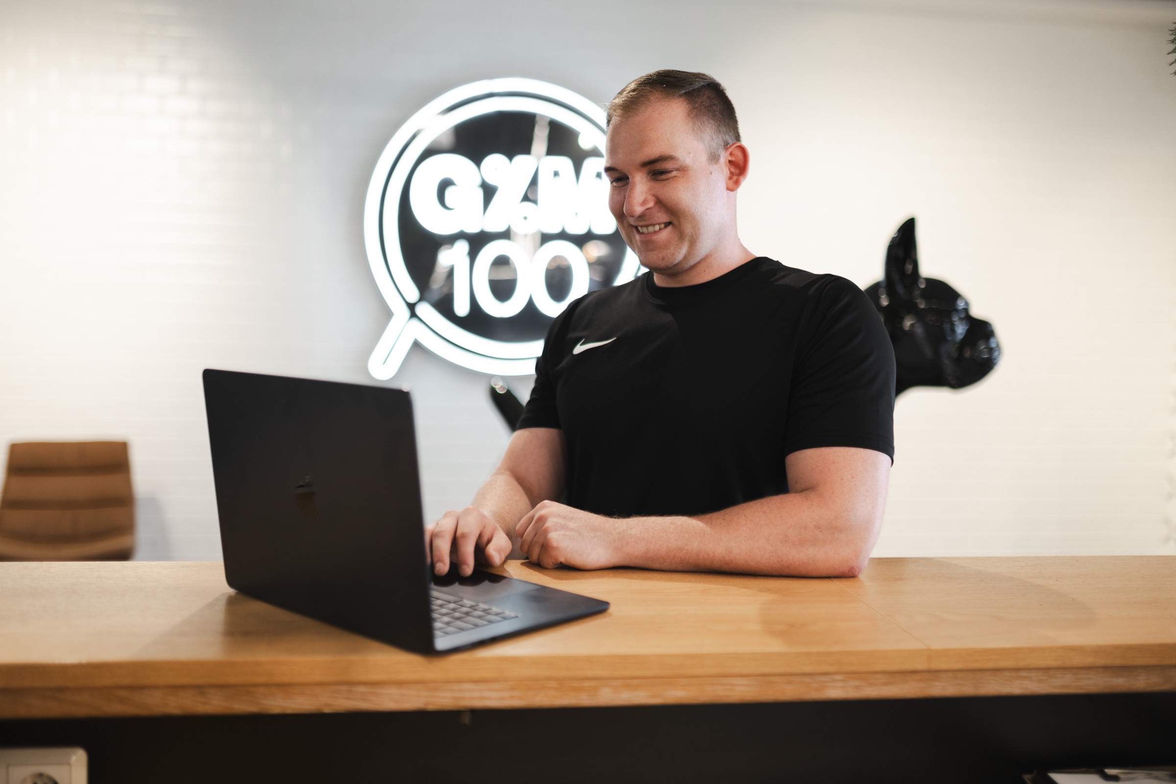 Justin arbeitet im Gym an einem Laptop.